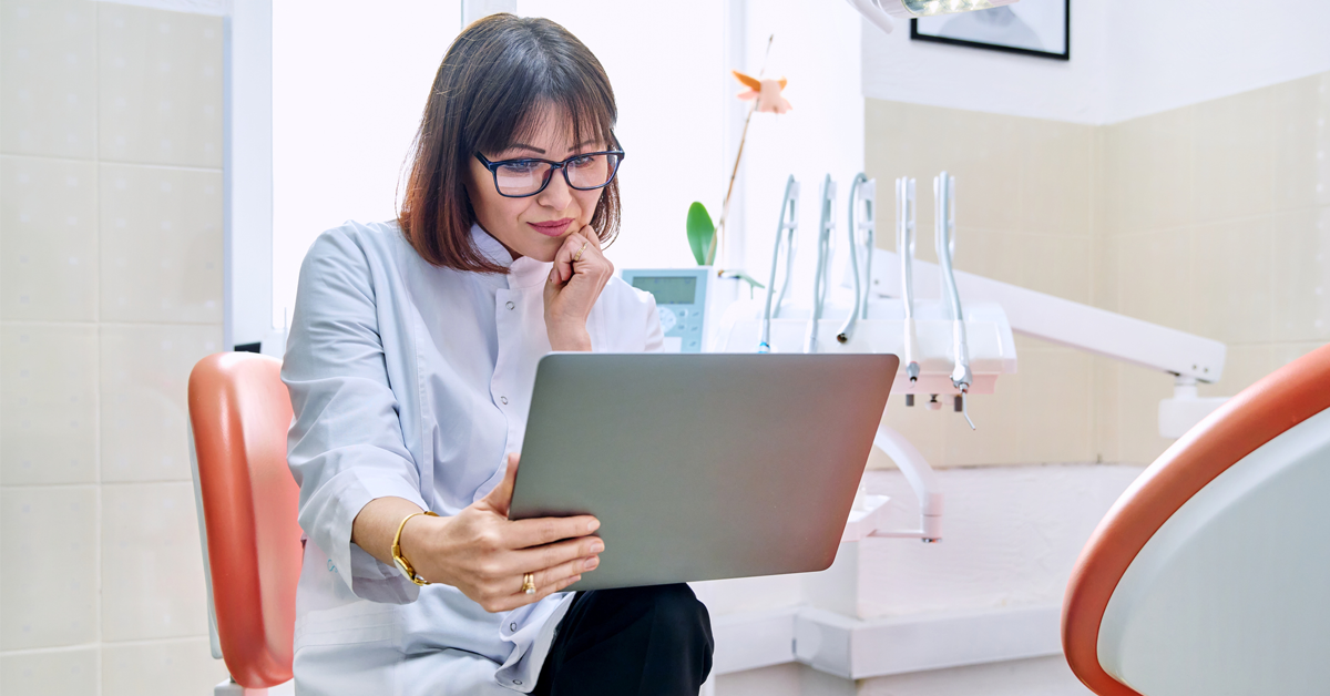 A dentist reads her tablet 