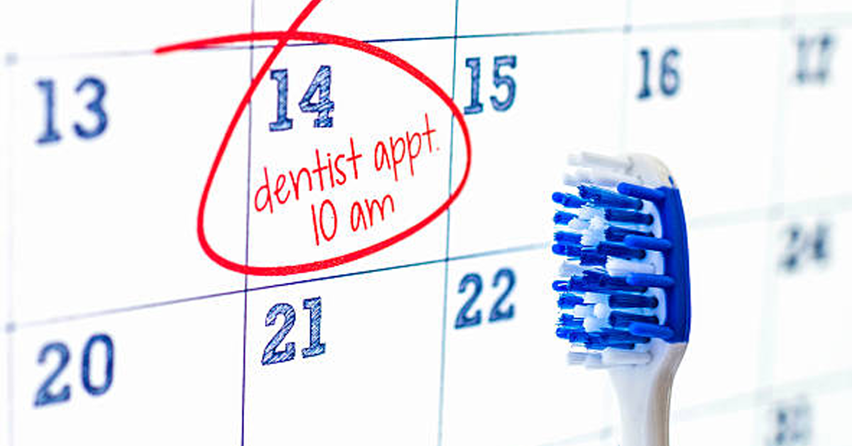 Calendar with dentist appointment written reminder and toothbrush next to it