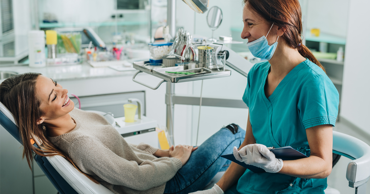 a dentist puts a lapsed patient at ease by answering her questions and making her less nervous with empathy