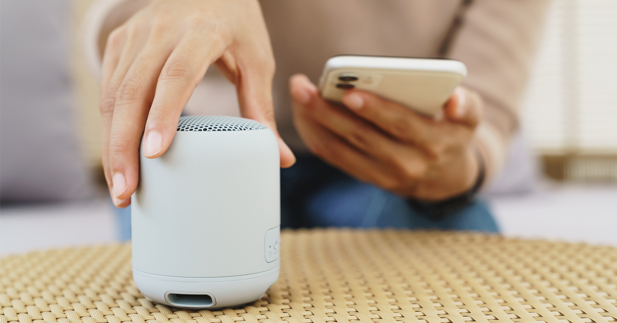 a hand reaches out to turn on a bluetooth speaker at the office