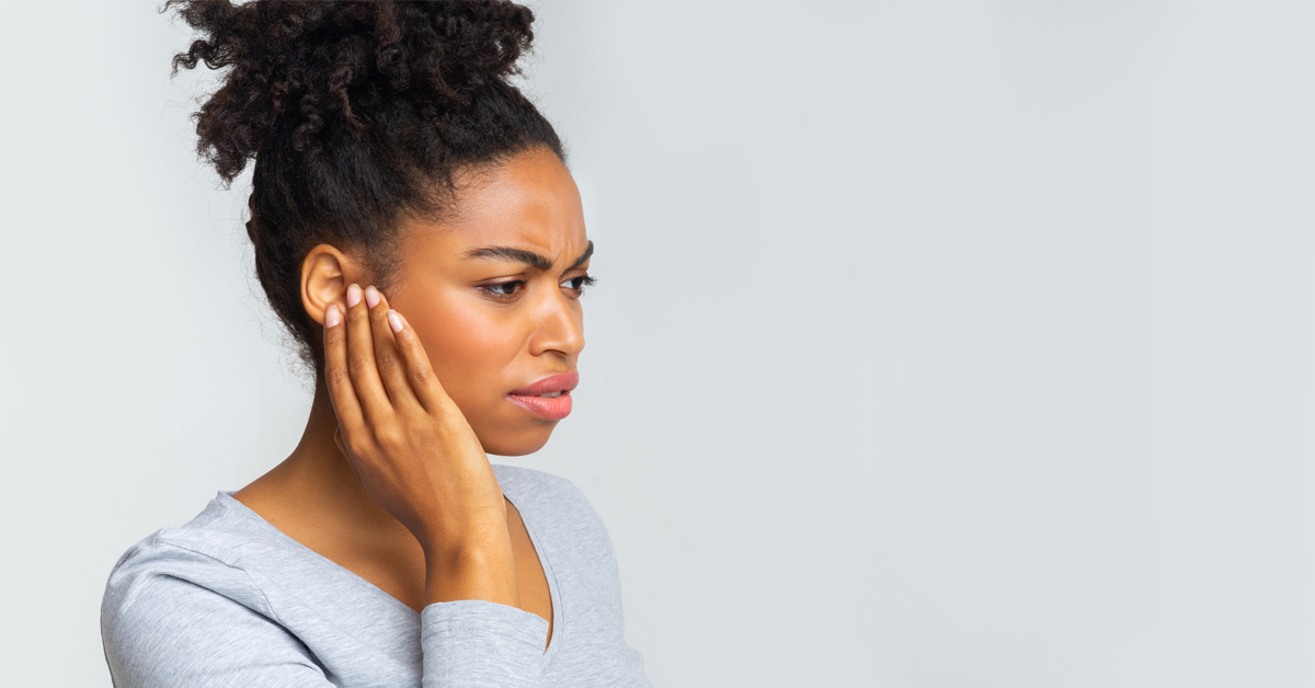 a woman's jaw is sore after clenching it when stressed