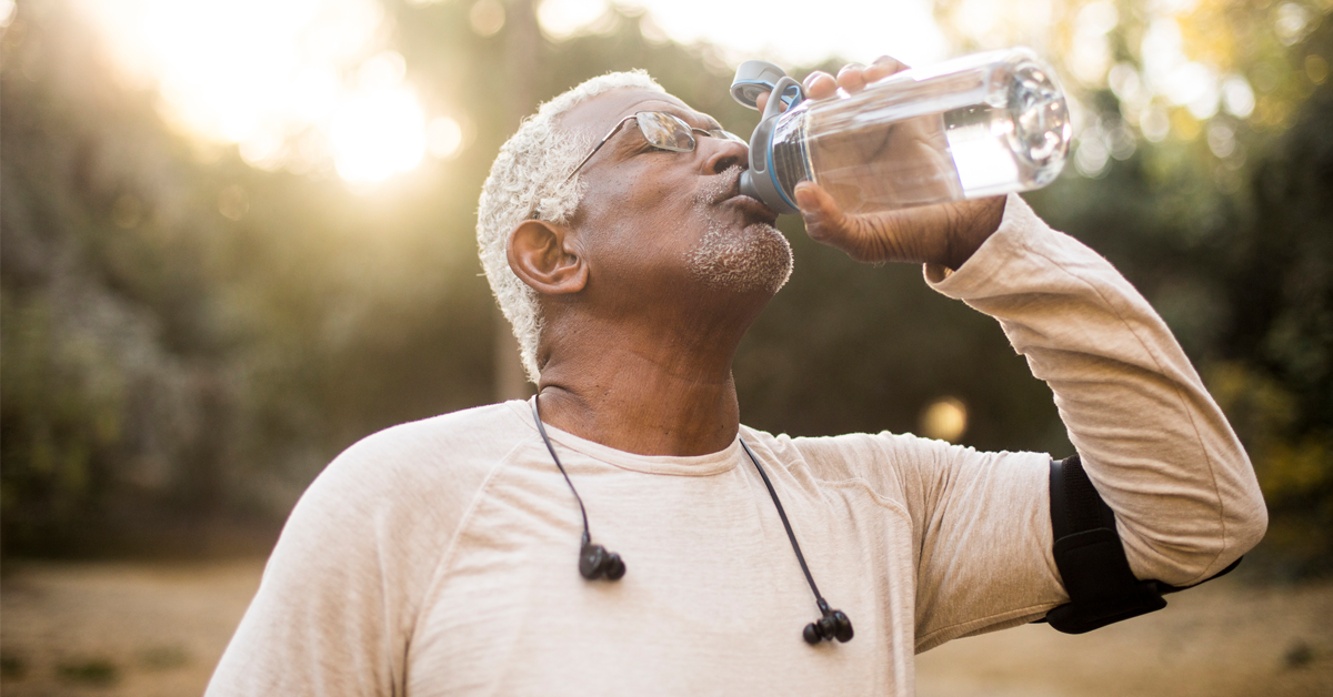 a man drinks water after a walk